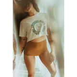 White cropped t-shirt with circular medallion by Polished Prints promoting empowered women