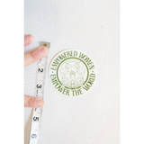Circular green Empowered Women sticker with the message Empowered Women Empower The World