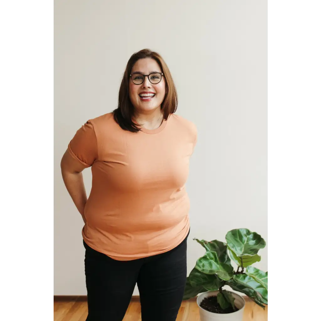 Cheerful person in peach tee showcasing the Toasted Unisex Adult Tee in organic cotton