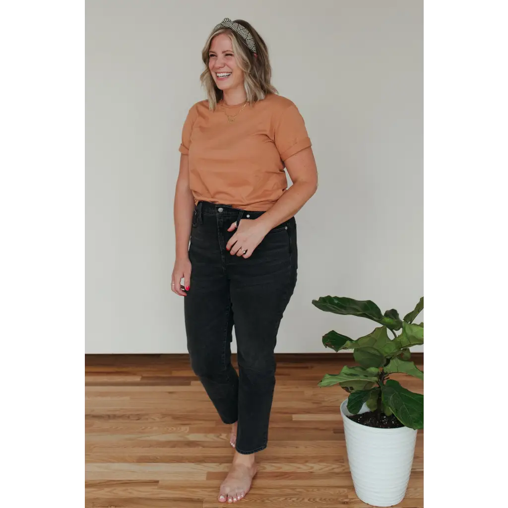 Person in a peach Toasted Unisex Adult Tee made of organic cotton, stylishly comfy