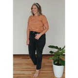 Person in a peach Toasted Unisex Adult Tee made of organic cotton, stylishly comfy