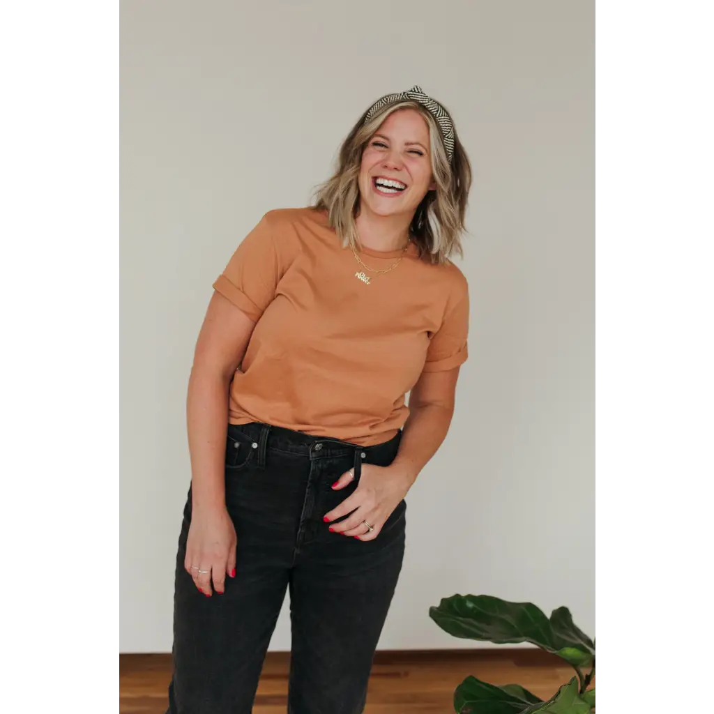 Joyful person in rust-colored Toasted Unisex Adult tee made from organic cotton