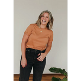 Joyful person in rust-colored Toasted Unisex Adult tee made from organic cotton
