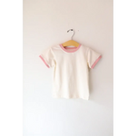 White basic everyday ringer tee with pink trim hanging on a stylish hanger