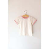 White basic everyday ringer tee with pink trim hanging on a stylish hanger