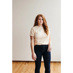 Person in cream Sunkiss Unisex Adult Tee, comfy organic cotton and dark jeans