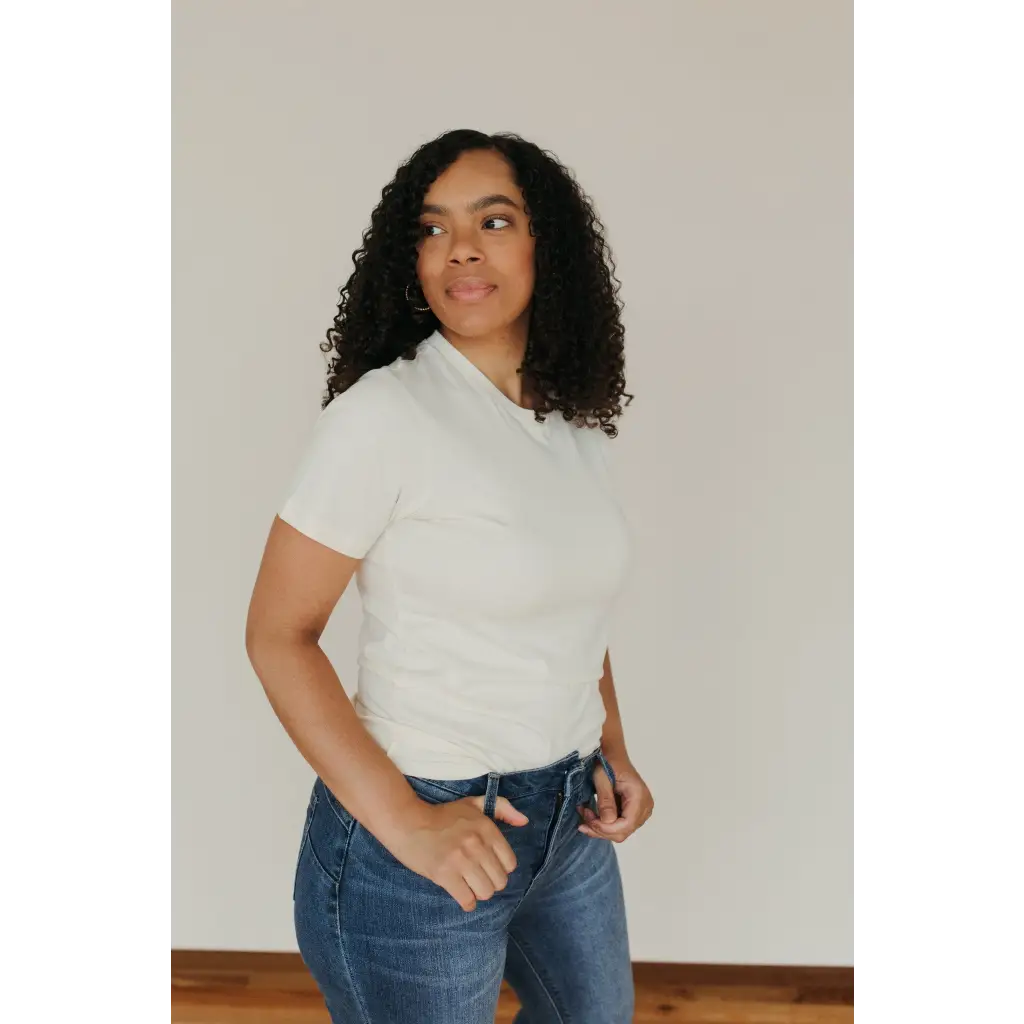 Person in white Natural Unisex Adult Tee made with organic cotton, styled with blue jeans