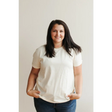 Woman in a white t-shirt and blue jeans, flaunting a Natural Unisex Adult Tee in Organic Cotton