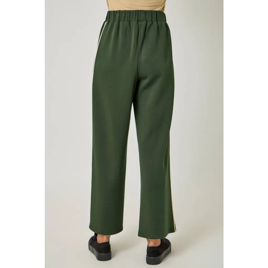 Olive green satin tracksuit pants with elastic waist and black slip-on shoes for stylish womens clothes