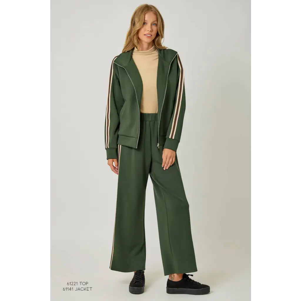 Green tracksuit pants with white stripes and black sneakers, stylish womens clothes