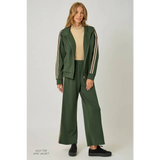 Green tracksuit pants with white stripes and black sneakers, stylish womens clothes