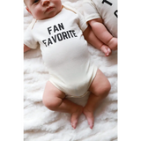 White baby onesie with FAN FAVORITE text, perfect go-to outfit for newborns and twins