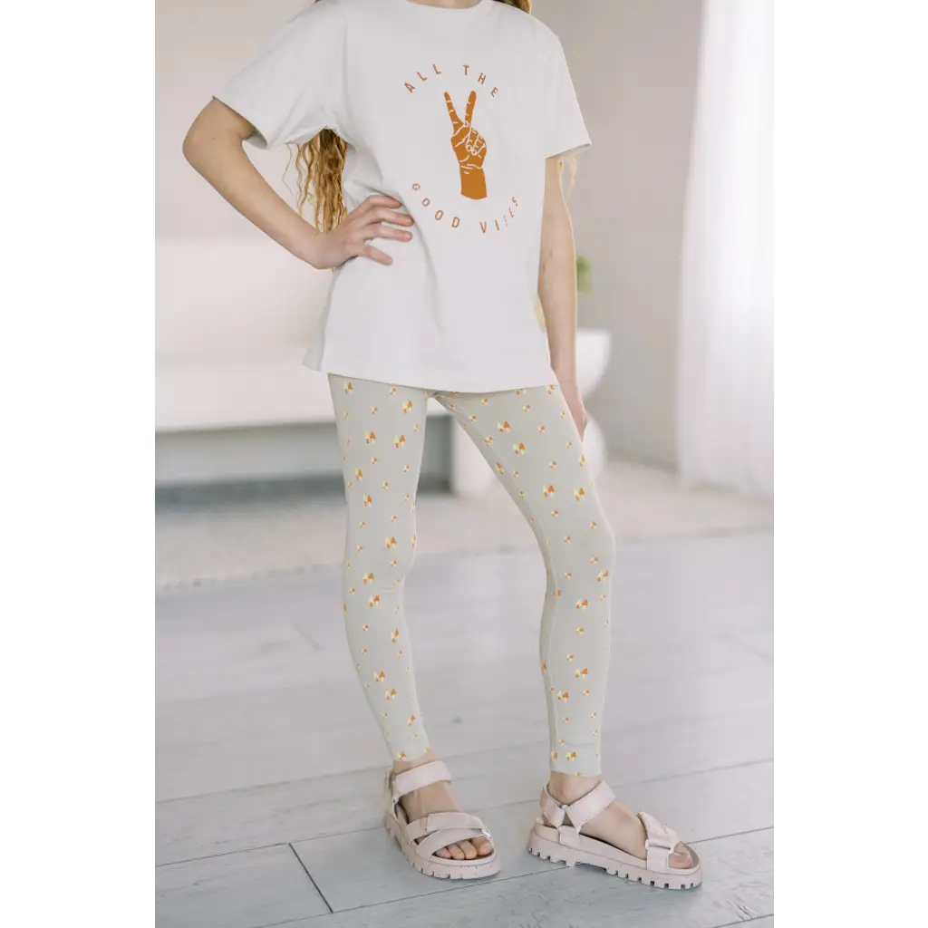 White t-shirt with peace sign, paired with good vibes lightweight leggings and sandals