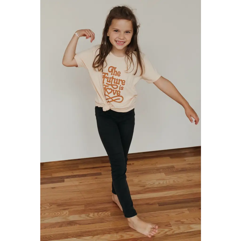 Child in Super Soft Organic Cotton Love T-shirt showing playful pose with dark pants
