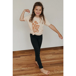 Child in Super Soft Organic Cotton Love T-shirt showing playful pose with dark pants