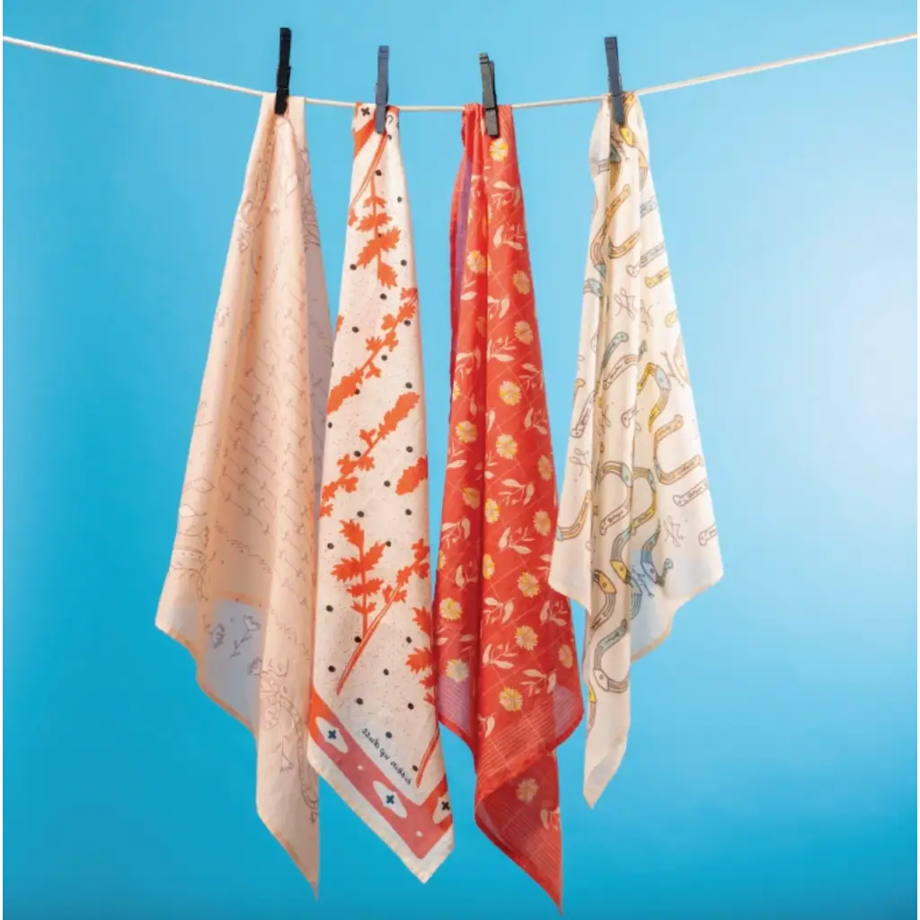 Four stylish scarves with polished prints hanging on a clothesline for moms and women