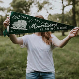 Dark green John Muir home pennant featuring vintage truck illustration and inspiring quote