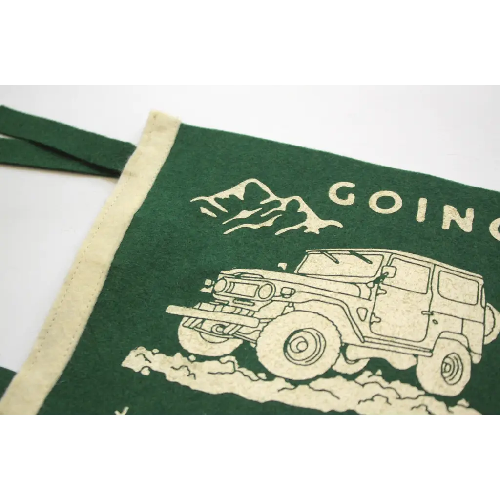 Green home pennant with John Muir design and off-road vehicle in a mountain setting