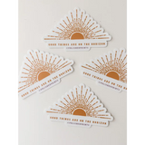 Four polished prints of Good Things are on the Horizon Stickers showcasing a rising sun design