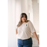 Person in a white vibes peace embroidered tee, rocking good vibes with blue jeans