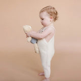 Toddler in cream romper cuddling teddy bear from Henry Bear Loves Spending Time line