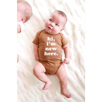 Brown Organic Cotton Baby Onesie featuring Hi, I’m New Here design for stylish newborns
