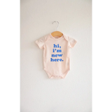 Baby onesie with blue text saying hi I’m new here in soft organic cotton for your little one