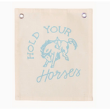 Light blue canvas banner featuring a bucking bronco design and text HOLD YOUR HORSES