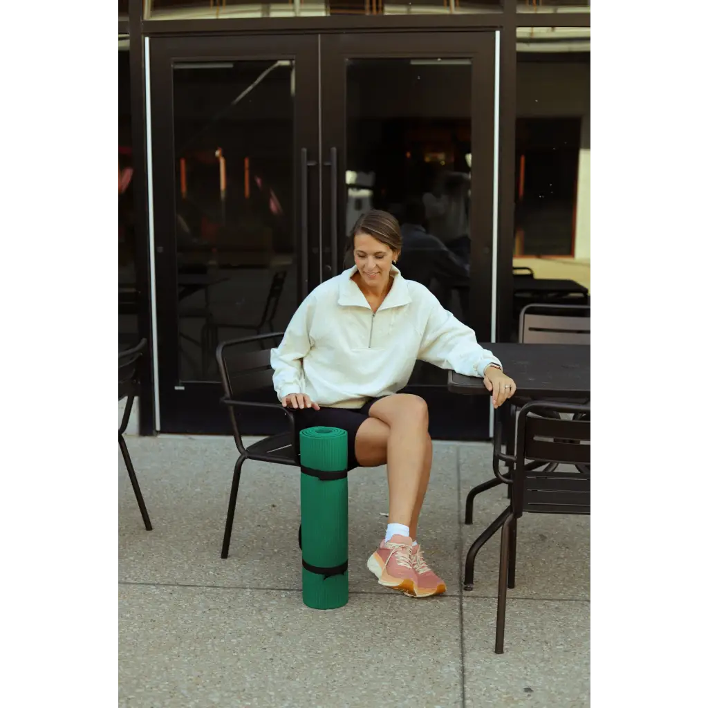 Person in a black metal chair rocking the Kate Fleece Pullover and pink sneakers