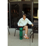 Person in a black metal chair rocking the Kate Fleece Pullover and pink sneakers