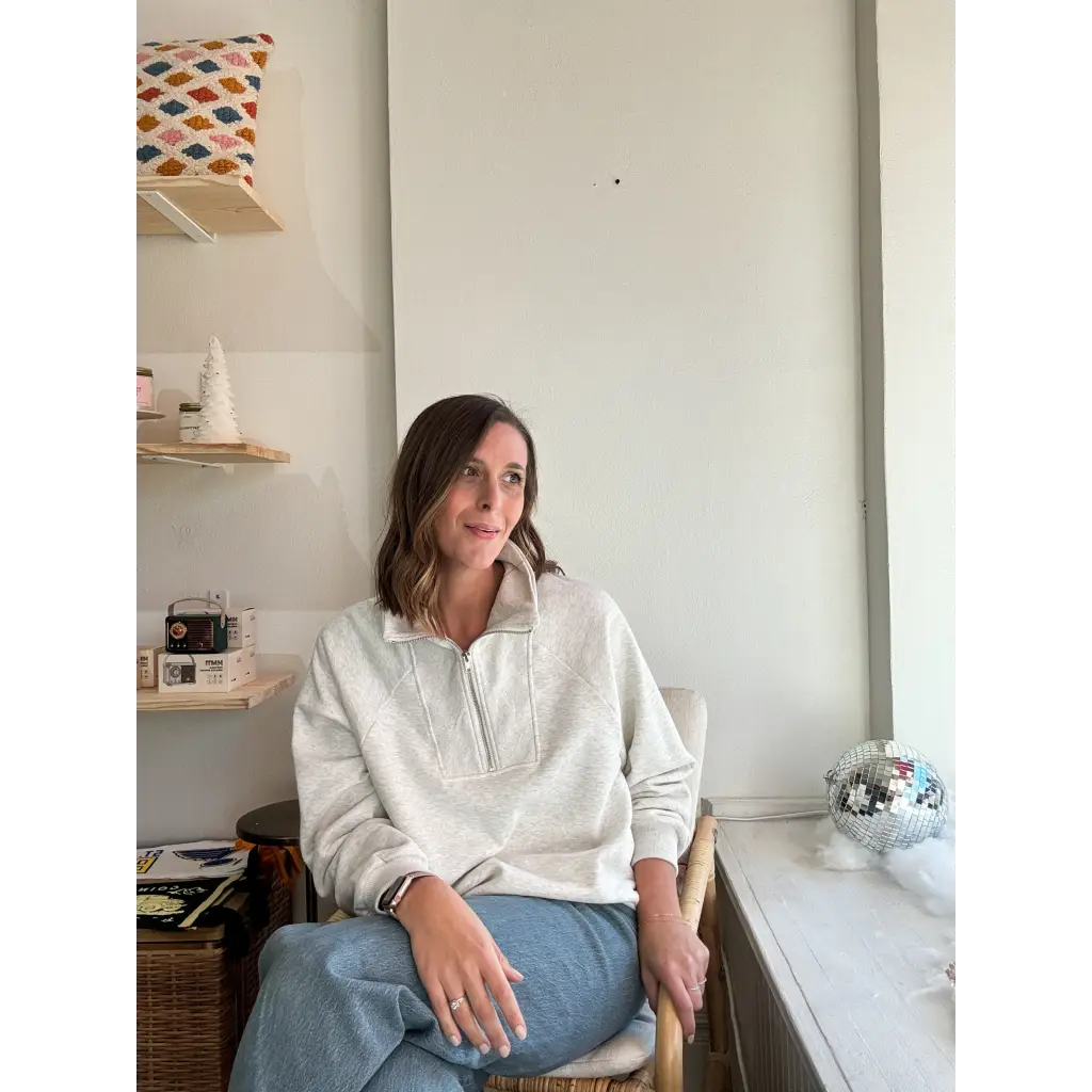 Person in a cream Kate Fleece Pullover and blue jeans, perfect for every gal’s wardrobe