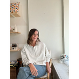 Person in a cream Kate Fleece Pullover and blue jeans, perfect for every gal’s wardrobe