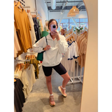 Casual look with Kate Fleece Pullover, black biker shorts, and tan sandals for every gal’s wardrobe