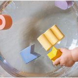 Yellow sponge over water with Floating Stacking Blocks in Natural Rubber and geometric figures