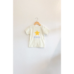 Child’s T-shirt with a star design, featuring rosy cheeks and elegant blue script