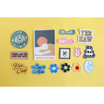 Colorful iron-on patches and polished prints on a bright yellow surface for stylish womens clothes