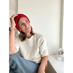 Person rocking a Lexi Beanie Hat in red with a cozy cream sweater for winter style