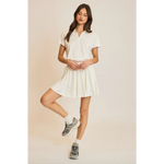 Woman in a white polo shirt and skirt modeling the Libby Athletic Mesh Romper with Front Zip