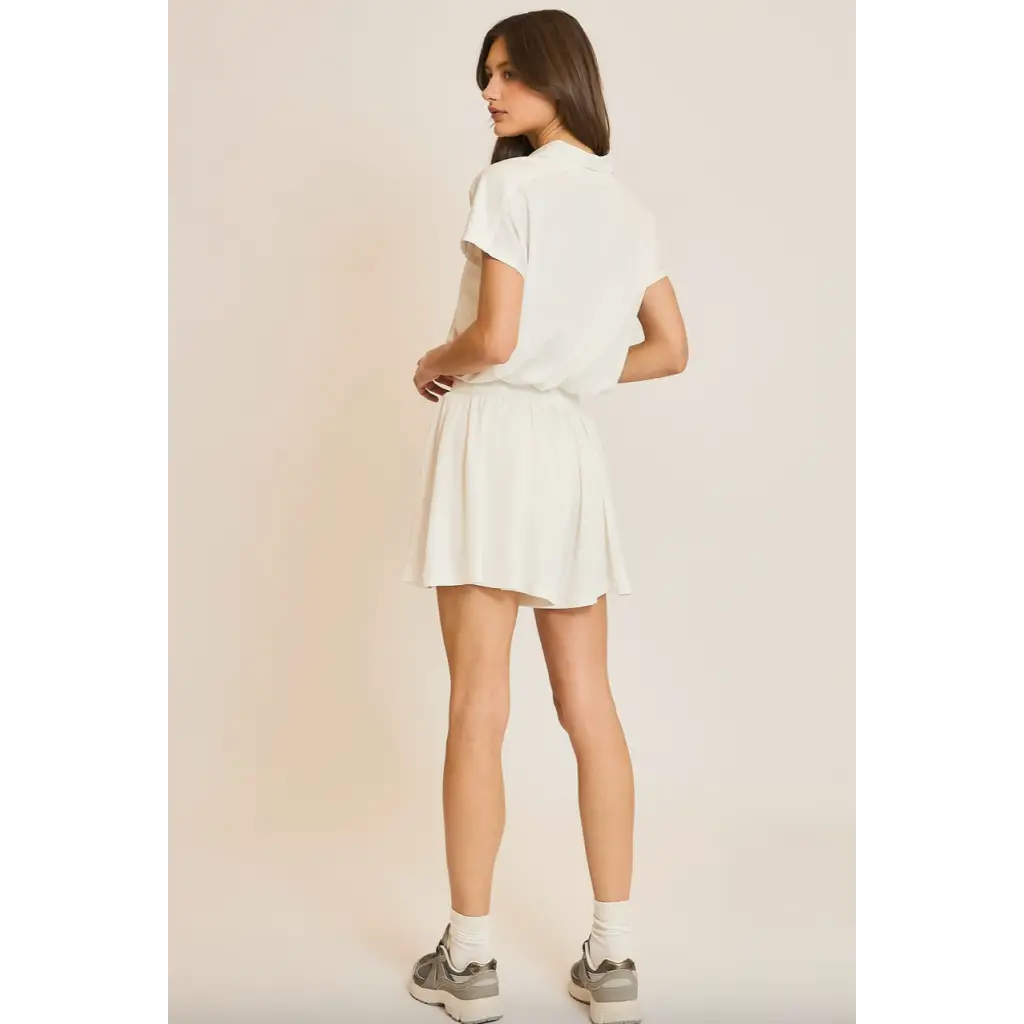 Woman in white shirt and skirt wearing Libby Athletic Mesh Romper with front zip