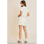 Woman in white shirt and skirt wearing Libby Athletic Mesh Romper with front zip