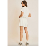 Woman in white shirt and skirt wearing Libby Athletic Mesh Romper with front zip