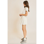 Woman in white T-shirt and skirt wearing Libby Athletic Mesh Romper showcasing lightweight athletic mesh