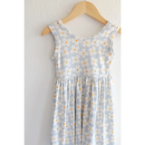 Light blue Libby Twirl Dress with daisy print hanging on wooden hanger for everyday fun