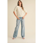 Woman wearing Liv Pointelle Knit Sweater with floral embroidery, cream open-knit top