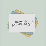 Handwritten lunch box note saying Have a great day on a card with colorful backgrounds