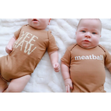 Two adorable babies in brown organic cotton onesies with polished prints, Yee Haw and Meatball