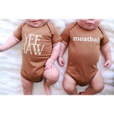 Two brown organic cotton baby onesies with polished prints YEE HAW and meatball designs