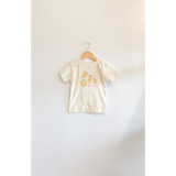 Child’s cream-colored T-shirt with hand-drawn pasta illustrations and classic crew neck