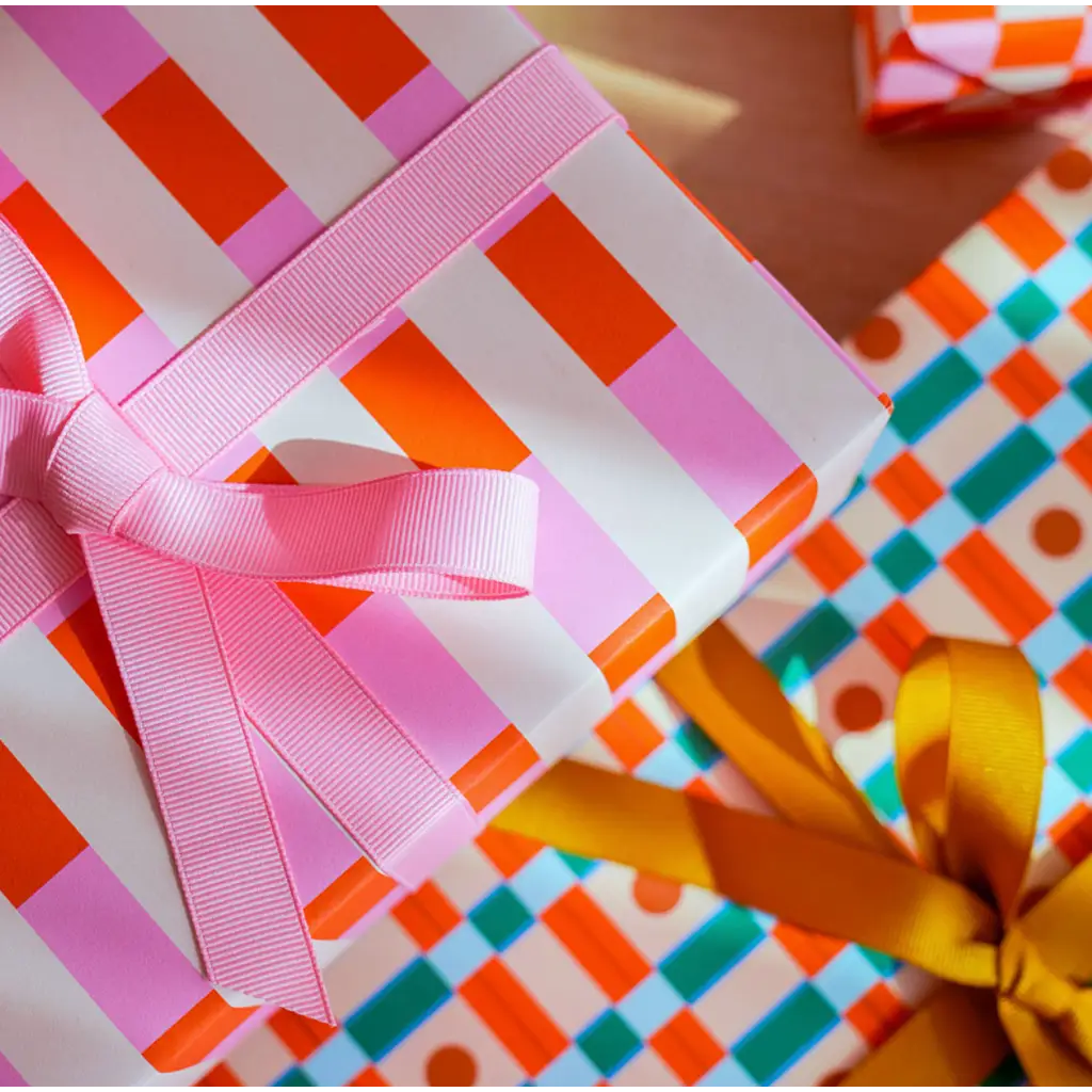 Gift wrapped in striped modern wrapping paper with a pink ribbon bow for a fun touch