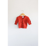 Buttery soft red mini grandpa cardigan sweater on a wooden hanger for the holiday season
